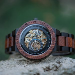 Descubre la elegancia y la artesanía en cada tic-tac con nuestro Reloj mecánico automático - R05-2. Este reloj combina la funcionalidad de la cuerda automática con un diseño elegante y distintivo, tallado con precisión para crear un efecto hueco único. La combinación de madera con bloques de color añade un toque de sofisticación y estilo a este reloj. Con su cierre de hebilla y su movimiento mecánico de alta calidad, es el complemento perfecto para cualquier ocasión. Con un diámetro de caja de 47,9 mm y un peso de 82 g, este reloj es cómodo de llevar y destaca en cualquier muñeca. El material del espejo Hardlex ofrece durabilidad y resistencia, mientras que la correa de ébano y sándalo verde/rojo añade un toque de lujo. Para mantener la belleza de la madera natural, recomendamos limpiarla con extracto de aceite de limón o naranja. Además, almacena este reloj en un lugar donde no esté expuesto a ambientes extremadamente cálidos, fríos o húmedos. Haz una declaración de estilo y elegancia con el Reloj mecánico automático - R05-2, una combinación perfecta de funcionalidad y diseño exquisito.